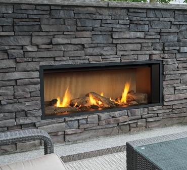L1 Outdoor Series gas fireplace with 1555LFB Adjustable Finishing Trim in Black, 1520FSL Fluted Sand Liner and Long Beach Driftwood Kit.